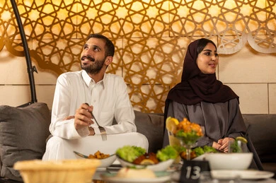 تبادل أطراف الحديث بين العائلات والزملاء، الاستمتاع بعطلة نهاية الأسبوع برفقة الأصدقاء في المطاعم والكافيهات،  زوجان عربيان خليجيان سعوديان يقضون السهرات المسائية الممتعة في الأجواء الصيفية اللطيفة ، تناول المشروبات الباردة المنعشة  في الهواء الطلق