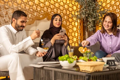 تبادل أطراف الحديث بين العائلات والزملاء،استخدام الهاتف المحمول ،  الاستمتاع بعطلة نهاية الأسبوع برفقة الأصدقاء في المطاعم والكافيهات،مجموعة اصدقاء عرب خليجيين سعوديين يقضون السهرات المسائية الممتعة في الأجواء الصيفية اللطيفة ، تناول المشروبات الباردة المنعشة  في الهواء الطلق