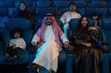 4D cinema hall, Arab Saudi Gulf audience in a cinema hall, modern display technologies, advanced audio, visual, and sensory cinematic effects, an imaginative cinematic experience, enjoying popcorn, facial expressions indicating joy and happiness, a family entertainment activity.