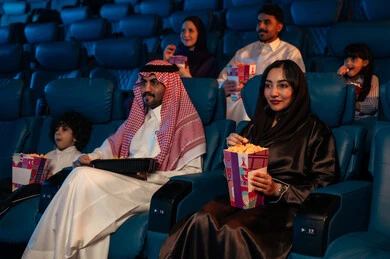 صالة عرض رباعية الأبعاد, تقنيات العرض الحديثه,جمهور عربي سعودي خليجي في صالة سينما،  المؤثرات الصوتيه والبصريه والحسيه السينمائيه المتطوره, تجربه سينمائيه خياليه، الاستمتاع بأكل الفشار، تعابير وجه تدل على الفرح والسعاده, نشاط عائلي ترفيهي