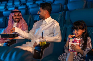 صالة عرض رباعية الأبعاد, تقنيات العرض الحديثه, جمهور عربي سعودي خليجي في صالة سينما،  المؤثرات الصوتيه والبصريه والحسيه السينمائيه المتطوره, تجربه سينمائيه خياليه، الاستمتاع بأكل الفشار، تعابير وجه تدل على الفرح والسعاده, نشاط عائلي ترفيهي