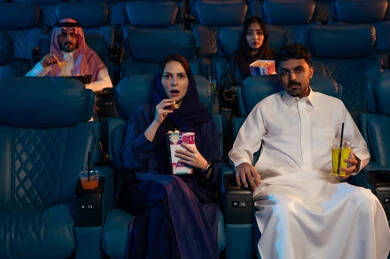 مشاهدة الأفلام والعروض المسرحية في السينما، تعابير الخوف والذعر ، أنشطة ترفيهية سعيدة، قضاء أوقات ممتعة، جمهور عربي سعودي خليجي في صالة السينما،  الإستمتاع بتناول الفشار والمشروبات الباردة ، سينما ومسرح، خلفية قاعة عرض السينما، صالة العرض