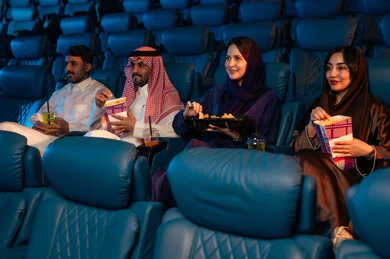 عطلة نهاية الأسبوع ، جمهور عربي سعودي خليجي في صالة السينما، تعابير تدل على الإندماج، الإستمتاع بتناول الفشار والمشروبات الباردة ، أنشطة ترفيهية، قضاء أوقات ممتعة، مشاهدة الأفلام والعروض المسرحية في السينما، سينما ومسرح، خلفية قاعة عرض السينما، صالة العرض