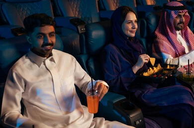 مشاهدة الأفلام والعروض المسرحية في السينما، تعابير تدل على الإندماج، الإستمتاع بتناول الفشار والمشروبات الباردة ،جمهور عربي سعودي خليجي في صالة السينما، أنشطة ترفيهية، قضاء أوقات ممتعة،سينما ومسرح، خلفية قاعة عرض السينما، صالة العرض