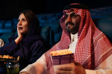 تعابير الخوف والذعر ، أنشطة ترفيهية سعيدة، قضاء أوقات ممتعة، رجل عربي سعودي خليجي في صالة السينما برفقة زوجته ،  الإستمتاع بتناول الفشار والمقرمشات ، مشاهدة الأفلام والعروض المسرحية في السينما، سينما ومسرح، خلفية قاعة عرض السينما، صالة العرض