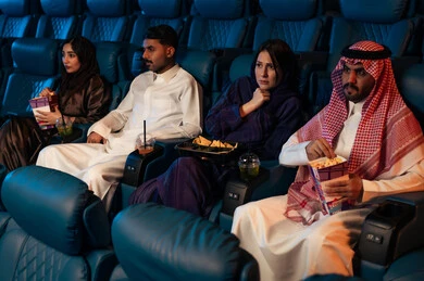 جمهور عربي سعودي خليجي في صالة السينما، الإستمتاع بتناول الفشار والمشروبات الباردة ، مشاهدة الأفلام المرعبه والعروض المسرحية في السينما، تعابير الخوف والذعر ،الاثارة والتشويق والاندماج ، قضاء أوقات ممتعة،سينما ومسرح، خلفية قاعة عرض السينما، صالة العرض