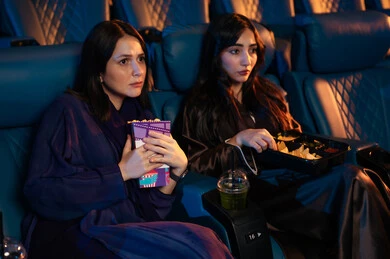 صديقتان عربيتان سعوديتان خليجيتان في صالة السينما ، مشاهدة الأفلام المرعبه والعروض المسرحية في السينما، تعابير الخوف والذعر ،الاثارة والتشويق والاندماج ، قضاء أوقات ممتعة،الإستمتاع بتناول الفشار والمشروبات الباردة ، سينما ومسرح، خلفية قاعة عرض السينما، صالة العرض