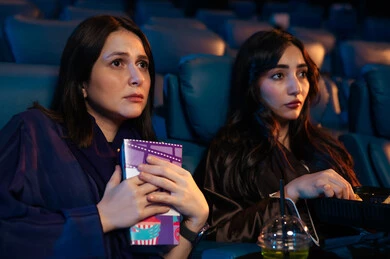مشاهدة الأفلام المرعبه والعروض المسرحية في السينما، تعابير الخوف والذعر ،الاثارة والتشويق والاندماج ، قضاء أوقات ممتعة، صديقتان عربيتان سعوديتان خليجيتان في صالة السينما ، الإستمتاع بتناول الفشار والمشروبات الباردة ، سينما ومسرح، خلفية قاعة عرض السينما، صالة العرض
