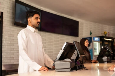 موظف عربي سعودي خليجي يرتدي الزي التقليدي  فى صاله حجز التذاكر لمشاهدة فيلم في صالة السينما،مشاهدة الأفلام والعروض المسرحية ،  أنشطه ترفيهيه متميزة