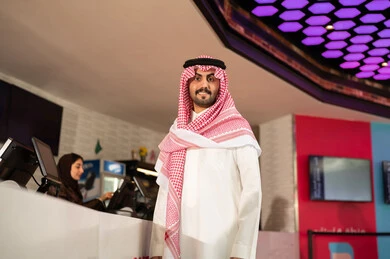 رجل عربي سعودي خليجي مبتسم يرتدي الزي التقليدي والشماغ ينظر الى الكاميرا فى صاله حجز التذاكر لمشاهدة فيلم في صالة السينما،متابعة الأفلام والعروض المسرحية ، أنشطه ترفيهيه متميزة رجل عربي سعودي خليجي مبتسم يرتدي الزي التقليدي والشماغ ينظر الى الكاميرا فى صاله حجز التذاكر لمشاهدة فيلم في صالة السينما،متابعة الأفلام والعروض المسرحية ، أنشطه ترفيهيه متميزة
