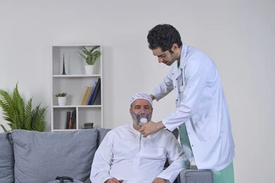 Inhaling medication for sleep apnea, maintaining a regular airway using a ventilator, providing home health care, portrait of a nurse wearing a medical coat applying an oxygen mask to an Arab Gulf Emirati patient, treating chronic asthma, white background