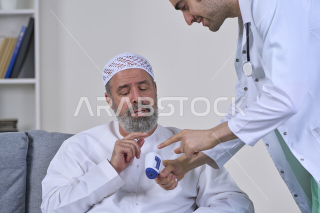 الوعي الصحي وتجنب إنتشار العدوى، إتباع إجراءات الوقاية و السلامة من فايروس كورونا، طبيب يحمل مقياس الحرارة الرقمي بالأشعة تحت الحمراء، بورتريه مقرب لممرض يقوم بفحص مريض مسن عربي خليجي اماراتي يرتدي الكندورة والقبعة، العمل في القطاع الطبي، خلفية بيضاء
