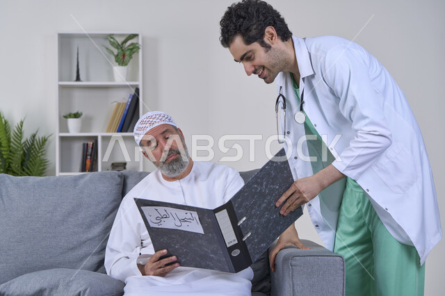 تقديم أفضل الخدمات الطبية المنزلية لمرضى كبار السن، متابعة السجل الطبي للمرضى, العمل في شركات التمريض المنزلي، بورتريه لممرض يرتدي اليونيفورم والمعطف الطبي يقوم بوصف الحالة المرضية لمريض مسن عربي خليجي اماراتي يرتدي الكندورة ويجلس على الكنبه، خلفية بيضاء