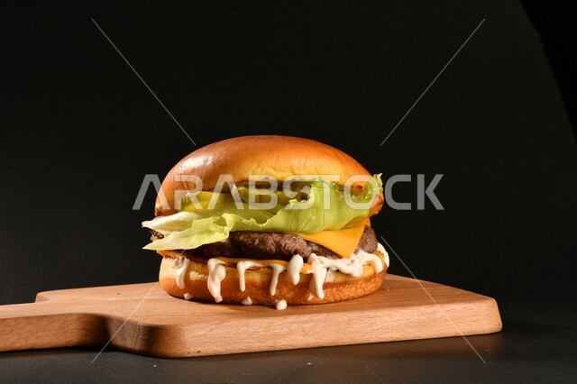 ساندويش البرجر اللذيذ بطبقات اللحم الطازج والجبن الذائب مع الطماطم والخس, مأكولات عربيه, وصفات طعام شهيه, وجبات طعام سريعه