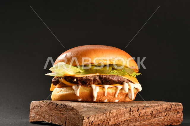 Delicious burger sandwich with layers of fresh meat and melted cheese with tomatoes and lettuce, Arabic food, delicious food recipes, fast food