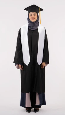 التقاط صور شخصية بثياب التخرج، بورتريه لإمرأة عربية خليجية سعودية مبتسمة ترتدي القبعة وعباءة التخرج تنظر الى الكاميرا بتعابير السرور والسعادة، خريجة اماراتية تحتفل بإنهاء المرحلة الجامعية، مفهوم التفوق والنجاح والاجتهاد، الجسم بالطول الكامل، خلفية بيضاء