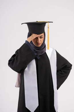 الارهاق والتعب بعد الاجتهاد والمثابرة، بورتريه لشابة عربية خليجية اماراتية ترتدي القبعة وزي التخرج تضع يدها على رأسها بتعابير اليأس، الانتهاء من مرحلة الدراسة الجامعية بعد عناء، خريجة اماراتية تنتظر نتائجها، خلفية بيضاء