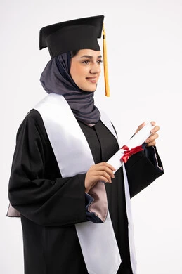 مفهوم النجاح والتفوق، الاحتفال بإنهاء الدراسة الجامعية، مناسبة واحتفال جامعي، شابة سعودية تنظر الى مكان ما بايماءات الفخر، تعابير السعادة بالوصول الى الحلم، بورتريه لخريجة عربية خليجية اماراتية محجبة ترتدي زي التخرج والقبعة تحمل بيدها الشهادة، خلفية بيضاء