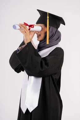التطلع الى المستقبل بعد التخرج، بورتريه من الجانب لشابة عربية خليجية سعودية مبتسمة ترتدي القبعة وزي التخرج تمسك الشهادة كالمنظار، خريجة اماراتية تحتفل بانتهاء مرحلة الدراسة الجامعية، النجاح والتفوق والاجتهاد، خلفية بيضاء