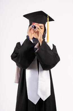 الرؤية المستقبلية بعد التخرج، بورتريه لشابة عربية خليجية سعودية مبتسمة ترتدي القبعة وزي التخرج تمسك الشهادة كالمنظار، خريجة اماراتية تحتفل بانتهاء مرحلة الدراسة الجامعية، النجاح والتفوق والاجتهاد، خلفية بيضاء