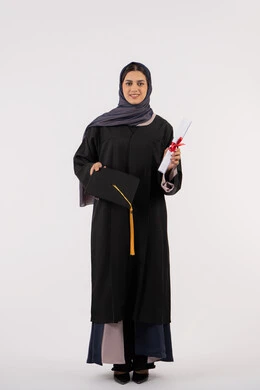 الاستعداد لرمي القبعة احتفالا بالنجاح وانتهاء المرحلة الجامعية، بورتريه لخريجة عربية خليجية اماراتية ترتدي قبعة وزي التخرج تمسك بيدها الشهادة، شابة سعودية تقف بتعابير وايماءات السرور والسعادة، مفهوم التفوق والاجتهاد، الجسم بالطول الكامل، خلفية بيضاء