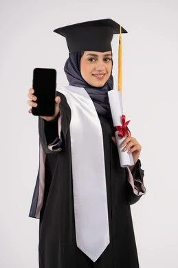 عرض شاشة سوداء فارغة على الهاتف المحمول، بورتريه لشابة عربية خليجية سعودية ترتدي القبعة وزي التخرج تمسك بيدها الشهادة، خريجة اماراتية مبتسمة تقف بتعابير السرور والسعادة، تطبيقات الدراسة اونلاين، الاحتفال بانتهاء المرحلة الجامعية، خلفية بيضاء