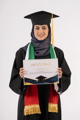 النظر الى الكاميرا بايماءات الفخر، النجاح والتفوق والتخرج من الجامعة، إيماءات السعادة بالوصول الى الحلم، مناسبة واحتفال جامعي، الاحتفال بإنهاء الدراسة الجامعية، بورتريه لخريجة عربية خليجية اماراتية محجبة ترتدي زي التخرج والقبعة تحمل بيدها الشهادة، خلفية بيضاء