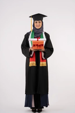 Celebrating the completion of university studies, the concept of diligence and excellence, expressions of happiness at achieving the dream of success, giving gifts on occasions, a university occasion and celebration, a portrait of a veiled Arab Gulf Emirati graduate wearing a graduation gown and cap, holding a gift box with a certificate, white background