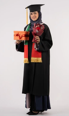 Celebrating the completion of university studies, giving gifts on occasions, university occasion and celebration, gestures of happiness for reaching the dream of success, portrait of a veiled Arab Gulf Emirati graduate wearing graduation dress and cap, holding a gift box with a bouquet of flowers, full body, white background