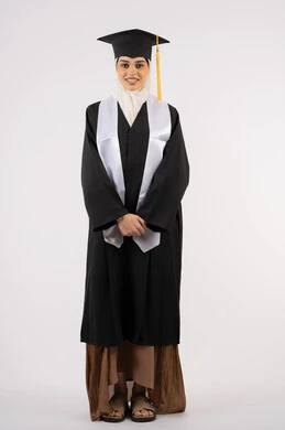 خريجة اماراتية تحتفل بإنهاء المرحلة الجامعية، الوقوف باستقامة والتقاط  صور شخصية بثياب التخرج، بورتريه لشابة عربية خليجية سعودية مبتسمة ترتدي القبعة وعباءة التخرج تنظر الى الكاميرا بتعابير السرور، مفهوم التفوق والنجاح والاجتهاد، صورة الجسم بالكامل، خلفية بيضاء