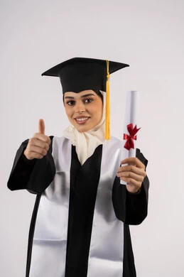 مناسبة وفرحة النجاح، رفع اصبع الابهام للأعلى بتعابير الاعجاب، التقاط  صور شخصية بثياب التخرج، خريجة اماراتية تحتفل بإنهاء المرحلة الجامعية، بورتريه لشابة عربية خليجية سعودية ترتدي القبعة وعباءة التخرج تحمل الشهادة وتنظر الى الكاميرا ايماءات السرور، خلفية بيضاء