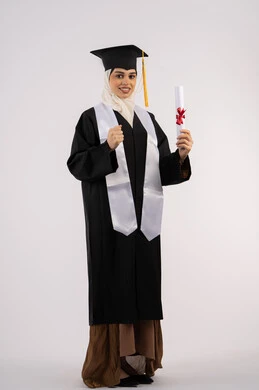 Raising a fist with an expression of achievement, looking at the camera with gestures of happiness and joy, celebrating reaching dreams, a Saudi graduate celebrating the completion of university, a portrait of an Arab Gulf Emirati woman wearing a graduation cap and gown and holding a certificate, full body image, white background