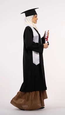 الاحتفال بالوصول إلى الأحلام وتحقيقها، إيماءات الثقة بالنفس، التقاط  صور شخصية بثياب التخرج، خريجة سعودية تحتفل بإنهاء المرحلة الجامعية، بورتريه من الجانب لامرأة عربية خليجية اماراتية ترتدي القبعة وعباءة التخرج وتحمل الشهادة، صورة الجسم بالكامل، خلفية بيضاء