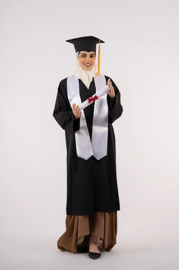 النظر إلى الكاميرا بإيماءات السعادة والفرح، الاحتفال بالوصول إلى الأحلام، التقاط  صور شخصية بثياب التخرج، خريجة سعودية تحتفل بإنهاء المرحلة الجامعية، بورتريه لامرأة عربية خليجية اماراتية ترتدي القبعة وعباءة التخرج وتحمل الشهادة، صورة الجسم بالكامل، خلفية بيضاء