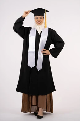 The importance of university studies, the concept of diligence and excellence, the joy of achieving success, gestures of joy, happiness and pride in reaching the dream of graduation, a portrait of a smiling veiled Saudi Arabian Gulf graduate wearing an abaya and graduation cap, a young Emirati woman celebrating the completion of her studies, a full body image, a white background