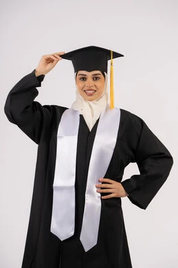 الفرح بتحقيق النجاح, أهمية الدراسة الجامعية، مفهوم الاجتهاد والتفوق، ايماءات البهجة والسعادة والفخر بالوصول لحلم التخرج، بورتريه لخريجة عربية سعودية خليجية محجبة مبتسمة ترتدي العباءة وقبعة التخرج، شابة إماراتية تحتفل بإنهاء دراستها، خلفية بيضاء