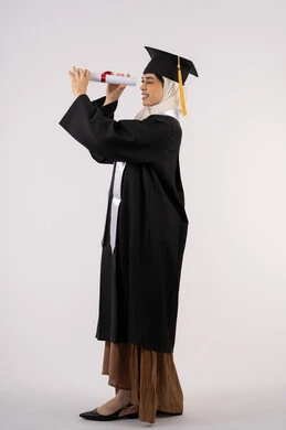 مشاعر الفخر والفرح بالوصول لحلم التخرج, التطلع إلى الأهداف والطموحات المستقبلية، بورتريه من الجانب لخريجة عربية سعودية خليجية محجبة ترتدي ثياب التخرج وتنظر من خلال شهادة التفوق، شابة إماراتية تحتفل بإنهاء دراستها، صورة لكامل الجسم، خلفية بيضاء