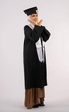 تعابير الأنوثة واللطافة، التقاط  صور شخصية بثياب التخرج، خريجة اماراتية تحتفل بإنهاء المرحلة الجامعية، بورتريه لشابة عربية خليجية سعودية مبتسمة ترتدي القبعة وعباءة التخرج تنظر الى الكاميرا بتعابير السرور، مفهوم التفوق والنجاح، صورة الجسم بالكامل، خلفية بيضاء