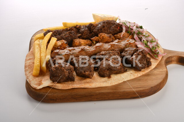 A plate of delicious and delicious mixed grills with crispy potato fingers, grilled meal, delicious meals, hot fast food, Arabic food