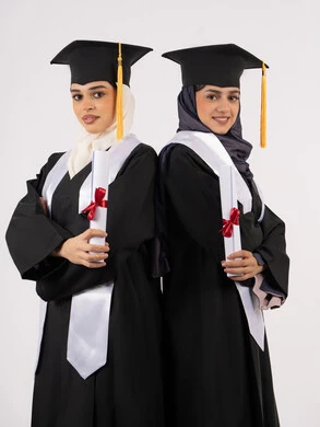 التعليم في جامعات الامارات العربية، الاحتفال بالتخرج من الجامعة، بورتريه لخريجتين جامعيتين عربيتين خليجيتين اماراتيتين ترتديان ملابس التخرج وتمسكان شهادة النجاح والتفوق، ايماءات السعادة والفرح والفخر، خلفية بيضاء