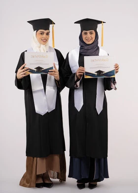 مفهوم الاجتهاد والتفوق، النظر إلى الكاميرا بإيماءات السعادة والفخر، الاحتفال مع الأصدقاء بالتخرج من الجامعة، بورتريه لخريجتين جامعيتين عربيتين خليجيتين اماراتيتين ترتديان ملابس التخرج وتمسكان شهادة النجاح، طول الجسم بالكامل، خلفية بيضاء