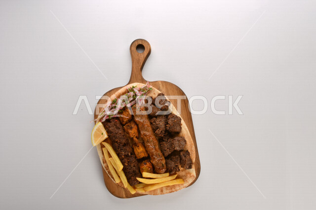 A plate of delicious and delicious mixed grills with crispy potato fingers, grilled meal, delicious meals, hot fast food, Arabic food