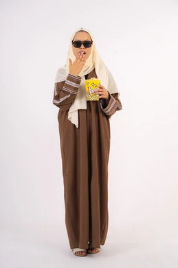 الحاجه الى النعاس والراحه ، تعابير التعب والارهاق ، بورتريه لامرأة عربية خليجية اماراتيه محجبة ترتدي عباءه وتحمل علبه فوشار ، متابعة الفيلم المفضل ، الاستمتاع باكل البوب كورن، مشاهدة الأفلام داخل السينما، التسلية والترفيه بقضاء أوقات ممتعة، خلفية بيضاء