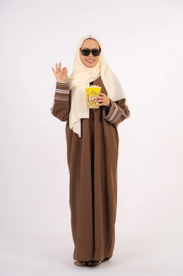 رفع اليد بتعابير الموافقه ، مشاهدة الأفلام داخل السينما، التسلية والترفيه بقضاء أوقات ممتعة، متابعة الفيلم المفضل ، الاستمتاع باكل البوب كورن، بورتريه لامرأة عربية خليجية اماراتيه محجبة ترتدي عباءه وتحمل علبه فوشار ، خلفية بيضاء