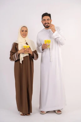 تناول الفوشار اثناء متابعة الأفلام والمسلسلات، قضاء وقت ممتع في السينما، بورتريه لزوجيين عربيين خليجيين اماراتيين مبتسميين ينظران الى الكاميرا بتعابير السرور والسعادة، الاستمتاع بالأنشطة العائلية الترفيهيه، خلفية بيضاء