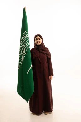 الاحتفال بتأسيس الدولة السعودية الأولى 22 فبراير، مفهوم حب الوطن و الانتماء اليه، يوم العلم السعودي11 مارس، ذكرى يوم بدينا 1727 م، بورتريه لإمرأة عربية خليجية سعودية ترتدي العباءة و الحجاب تمسك راية وشعار المملكة  بايماءات الاعتزاز و الفخر, الجسم بالطول الكامل, خلفية بيضاء