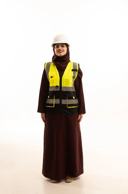 مفهوم ادارة المشاريع الهندسية, وظائف ومهن نسائية, شابة سعودية تعمل في القطاع الهندسي, الوقوف بايماءات الثقة, بورتريه لمهندسة عربية خليجية سعودية ترتدي خوذة وسترة الحماية تقف باستقامة، صورة لكامل الجسم، خلفية بيضاء