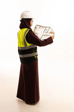 Review and presentation of project manuscripts in full, women's work in the engineering sector, the concept of engineering and architectural constructions, a portrait from the back of a Saudi Gulf Arab female engineer wearing a safety vest and helmet holding a construction plan, project management and follow-up, full-body, white background. Review and presentation of project manuscripts in full, women's work in the engineering sector, the concept of engineering and architectural constructions, a portrait from the back of a Saudi Gulf Arab female engineer wearing a safety vest and helmet holding a construction plan, project management and follow-up, full-body, white background.