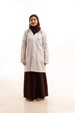 الوقوف باستقامة والنظر إلى الكاميرا بثقة, العمل في القطاع الصحي, بورتريه لطبيبة عربية خليجية سعودية ترتدي المعطف الطبي تنظر الى شيء ما ،  تقديم الخدمات العلاجية والفحوصات الطبية للمرضى, مهن ووظائف سعودية, ايماءات السعادة والسرور، الجسم باطول الكامل، خلفية بيضاء