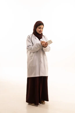 تقديم الاستشارات الطبية والخدمات الصحية، الاستماع إلى حالة المريض برحابة صدر و بشاشة، بورتريه لطبيبة عربية خليجية سعودية ترتدي المعطف الطبي تقوم بإعداد التقارير الطبية، مهن ووظائف سعودية، العمل في القطاع الصحي، الجسم بالطول الكامل، خلفية بيضاء